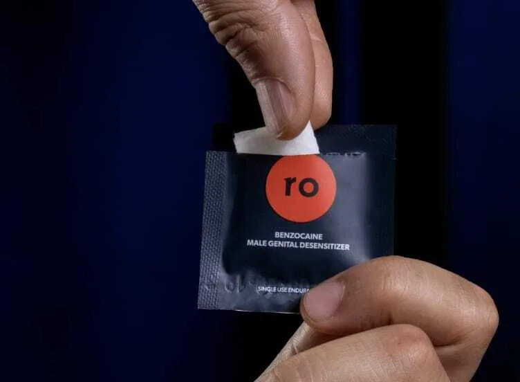 Man holding Benzocaine wipe with Roman swipe packet