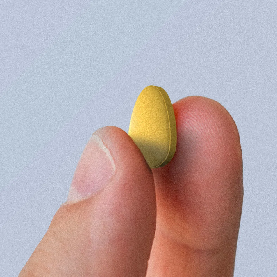 a Cialis pill held between two fingers