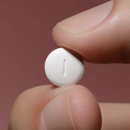 a generic of Viagra pill held between two fingers