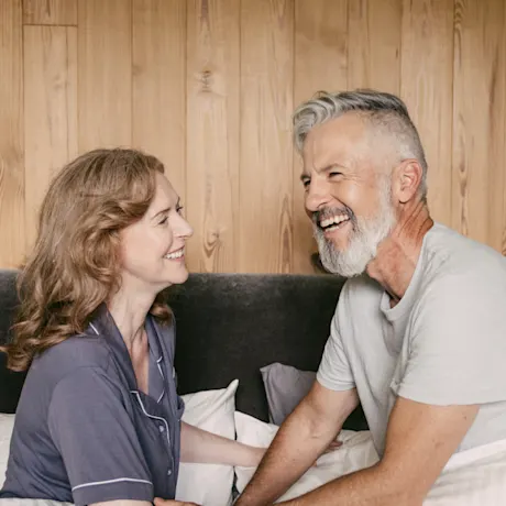 a couple laughing in bed