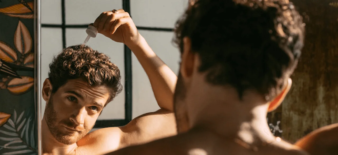man applying product on his scalp