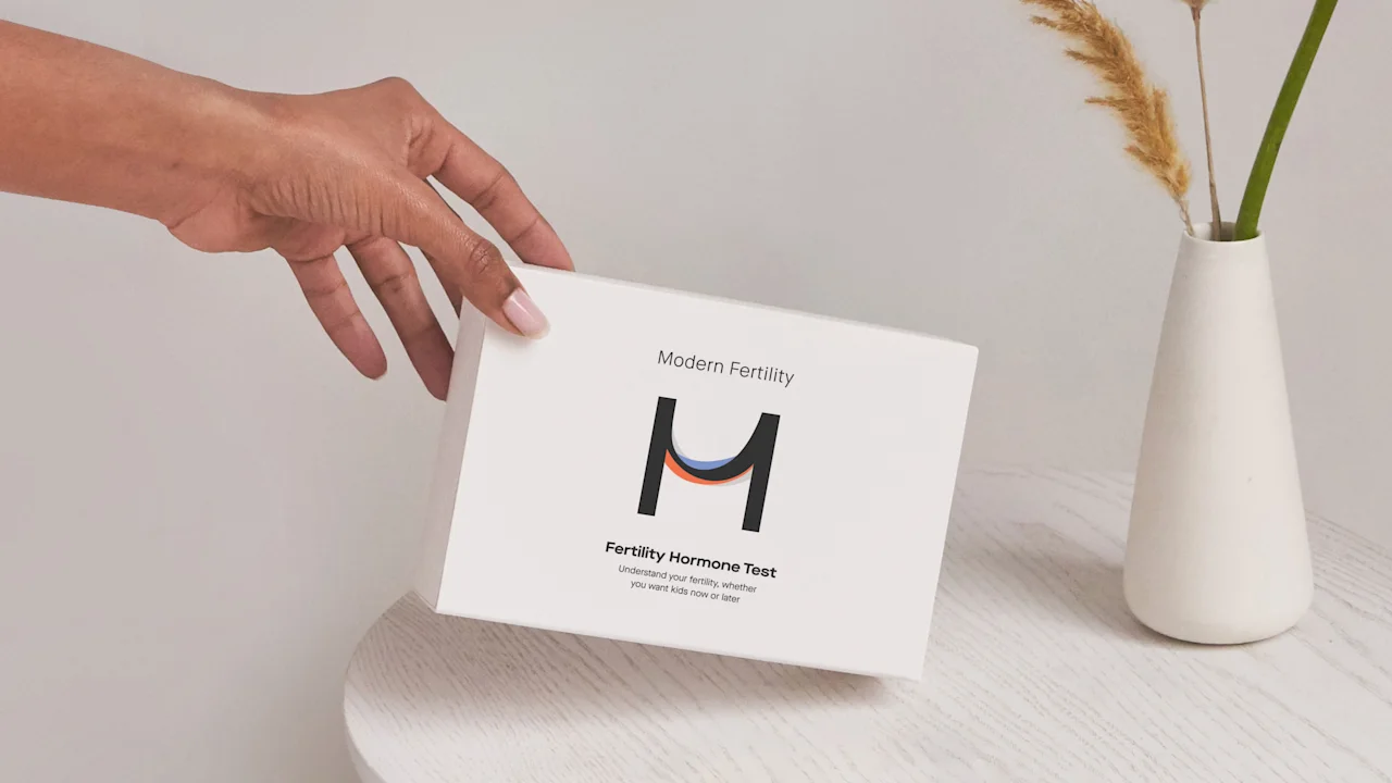 woman holding Modern Fertility hormone test box